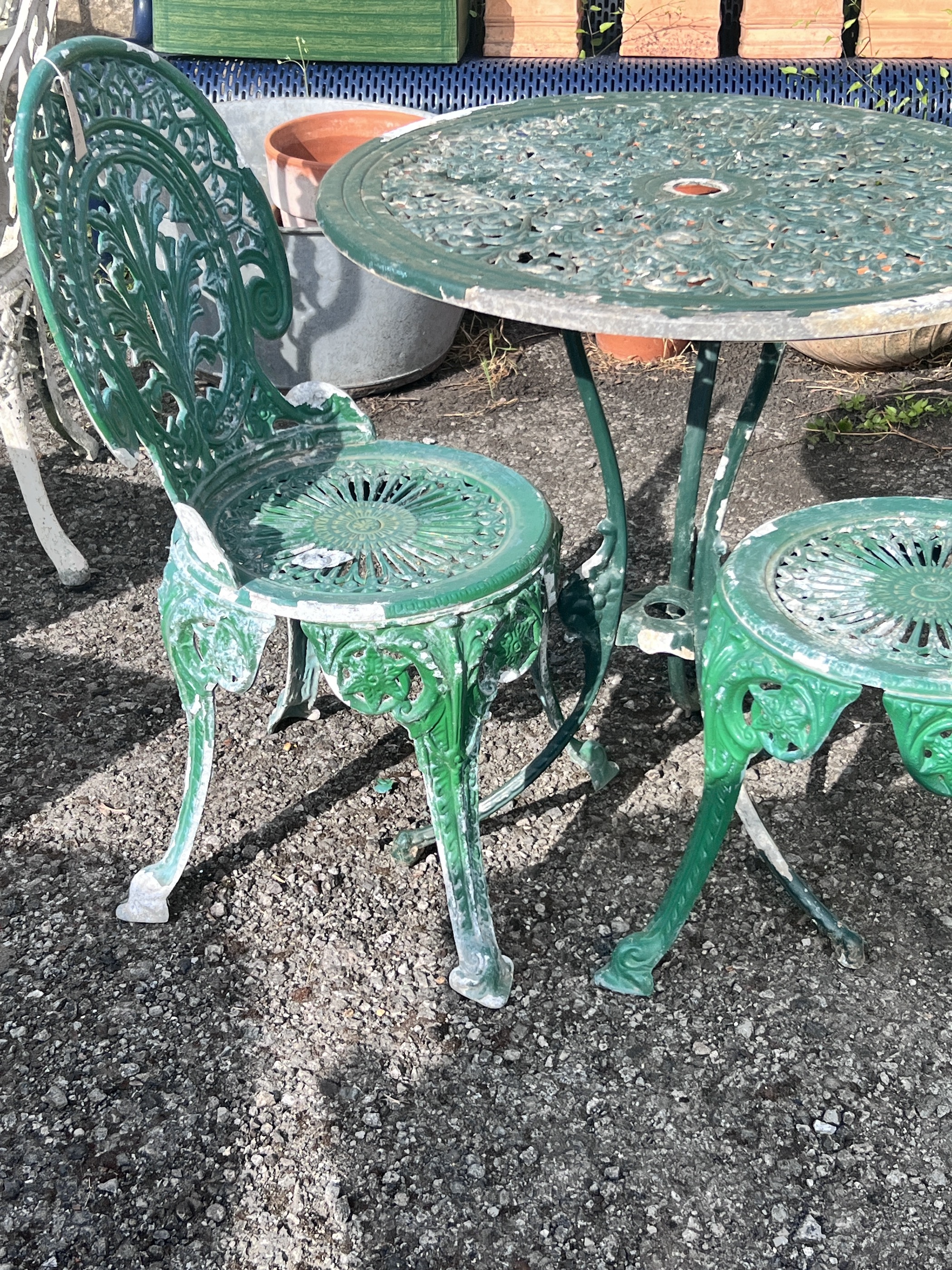 A circular aluminium garden table, diameter 69cm, height 72cm, together with two chairs